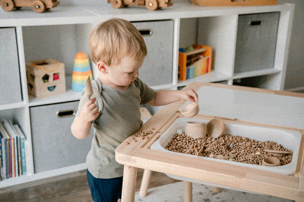 toddler boy playing with sensory bin
