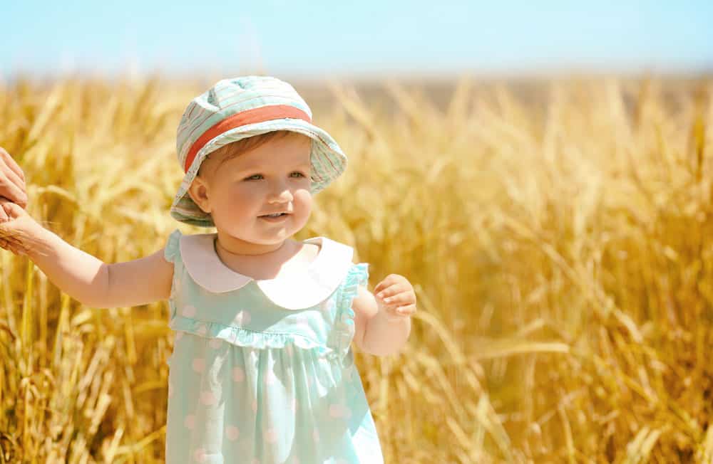 toddler girl in field in the summer for a post about middle names for Esther