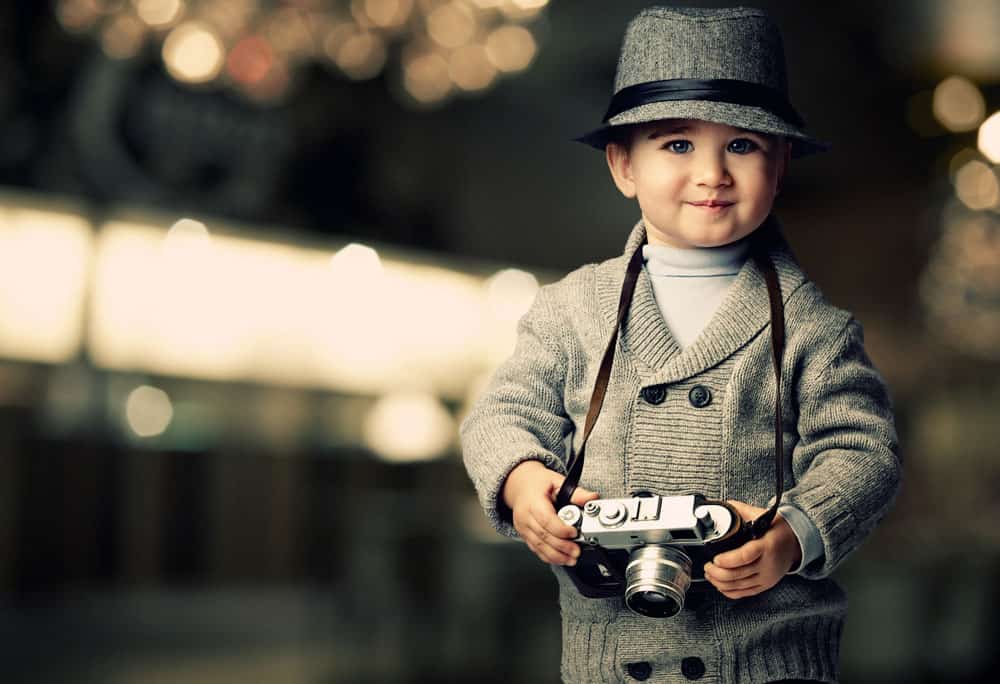 little boy holding vintage camera for a blog post about middle names for Harrison