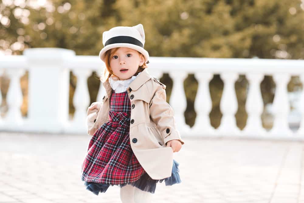 picture of toddler girl dancing in a dress and jacket for a post on middle names for Katherine