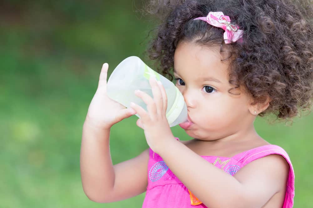 young toddler girl drinking milk from a bottle for a blog post on middle names for Natalie