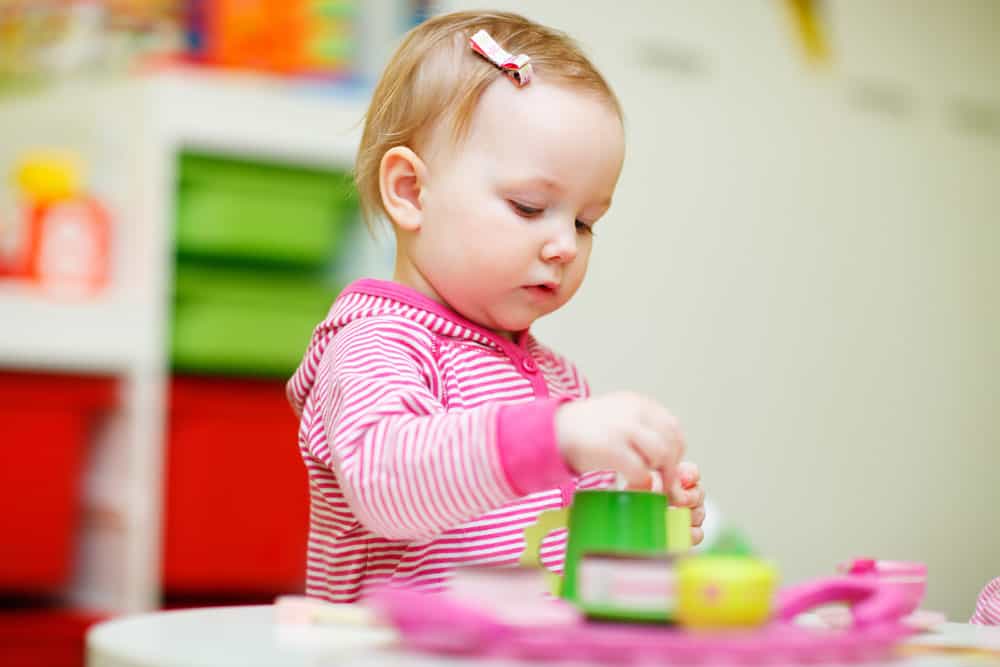 picture of baby girl playing with toy tea set for post on middle names for Penelope