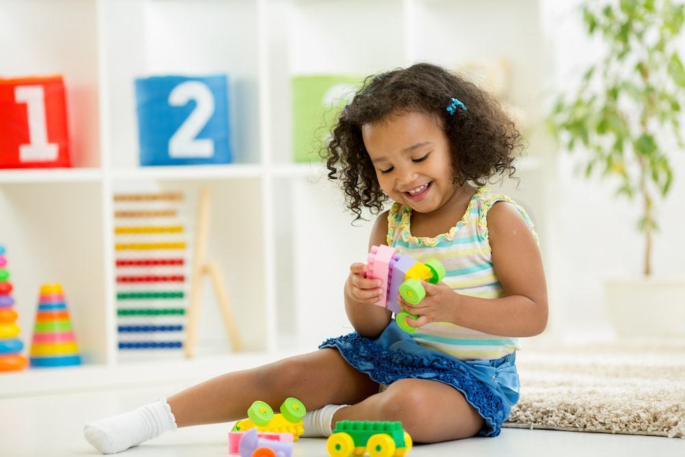 picture of little girl playing with blocks for a blog post on middle names for alani