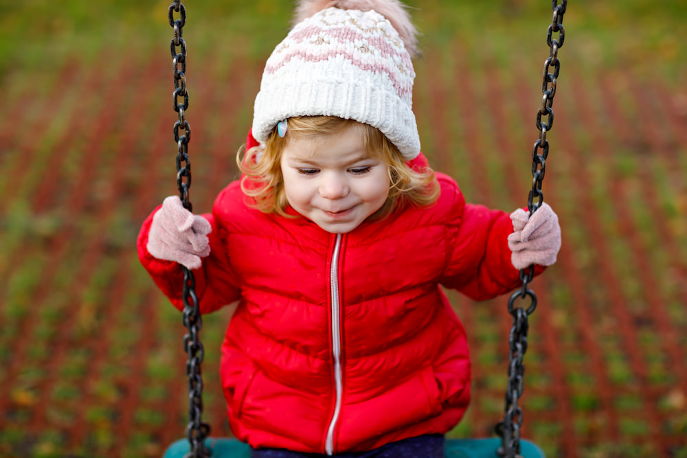 picture of little girl on swing for blog post about middle names for callie