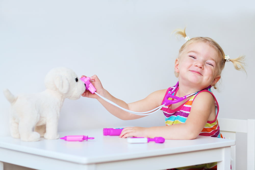 picture of little girl playing vet with a toy puppy for a blog post on middle names for ariella