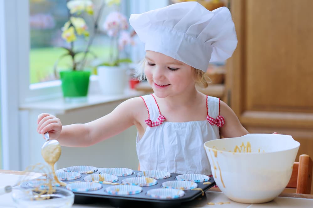 Picture of little girl baking cupcakes in the kitchen for a post about Middle Names for Blake