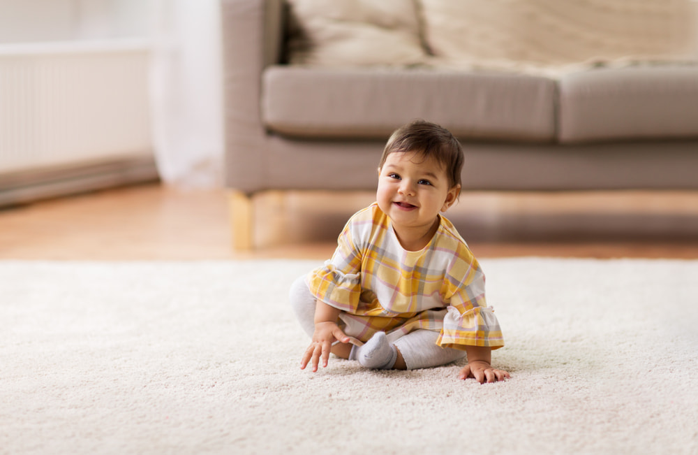picture of baby girl sitting on living room floor for a post about middle names for eliana