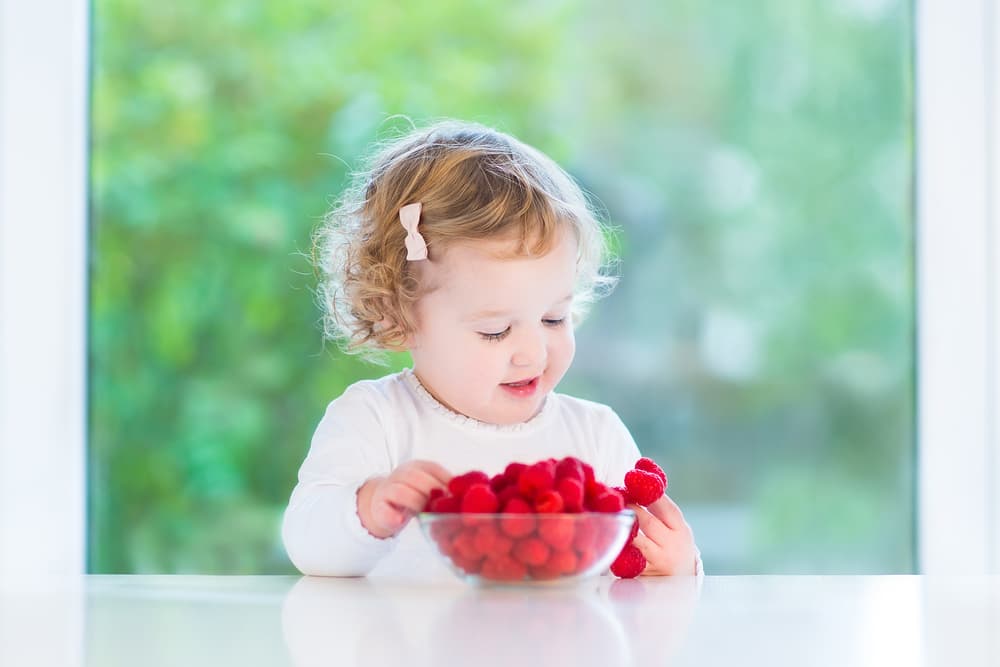 picture of toddler girl eating strawberries for blog post on middle names for paisley