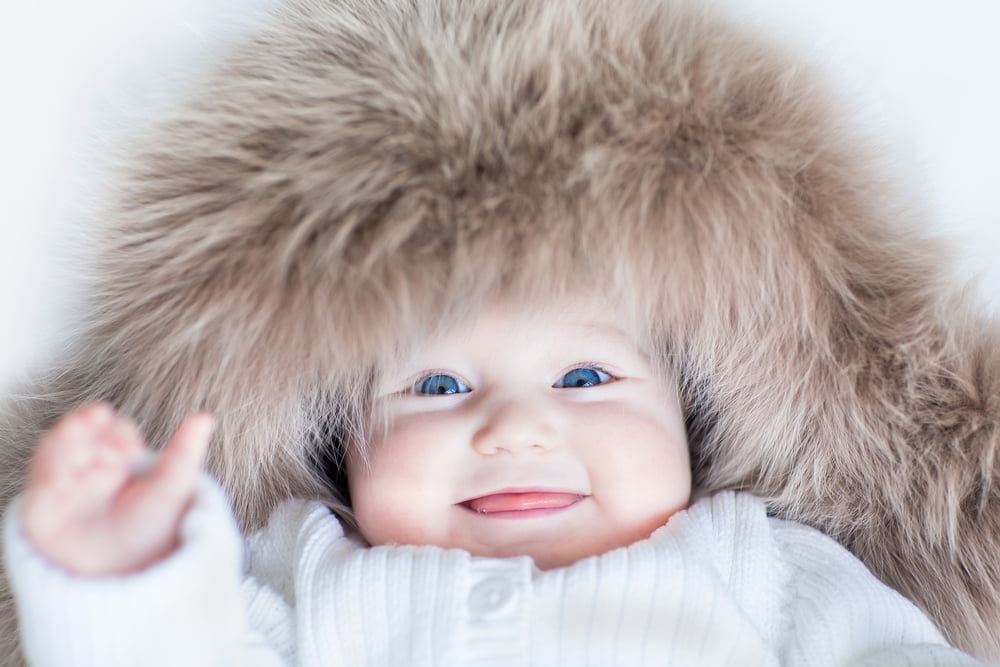 image of baby with fur hooded coat on