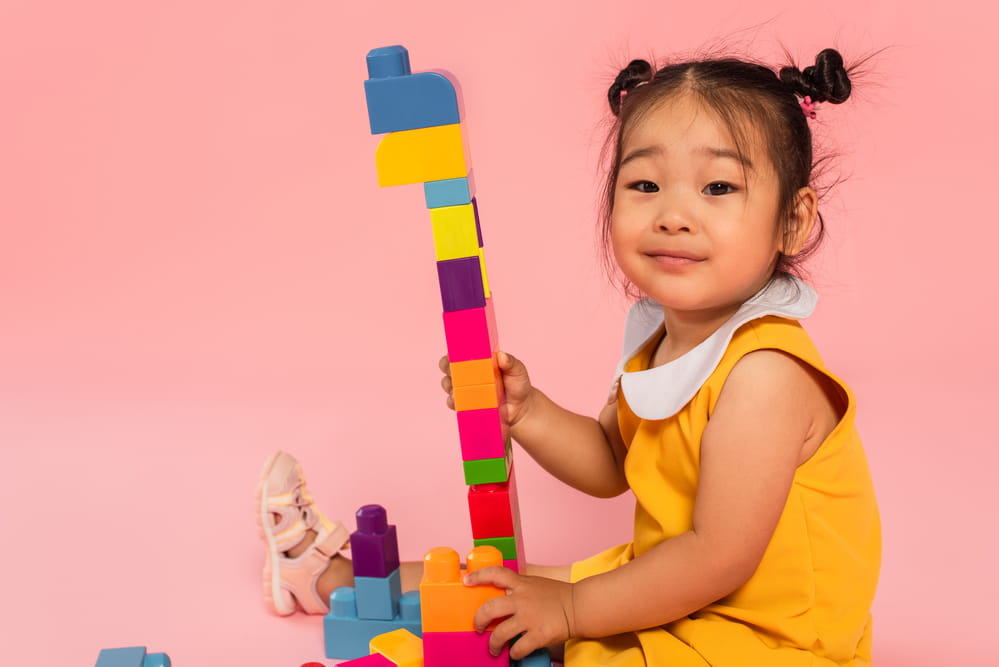 picture of toddler girl building a lego block tower