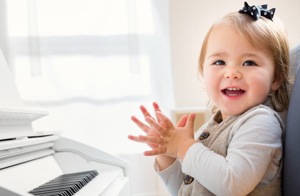 picture of toddler girl next to piano