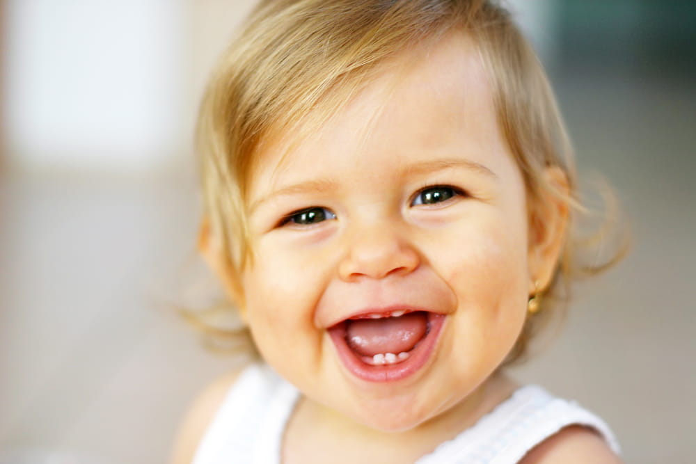 picture of baby girl smiling with white shirt on
