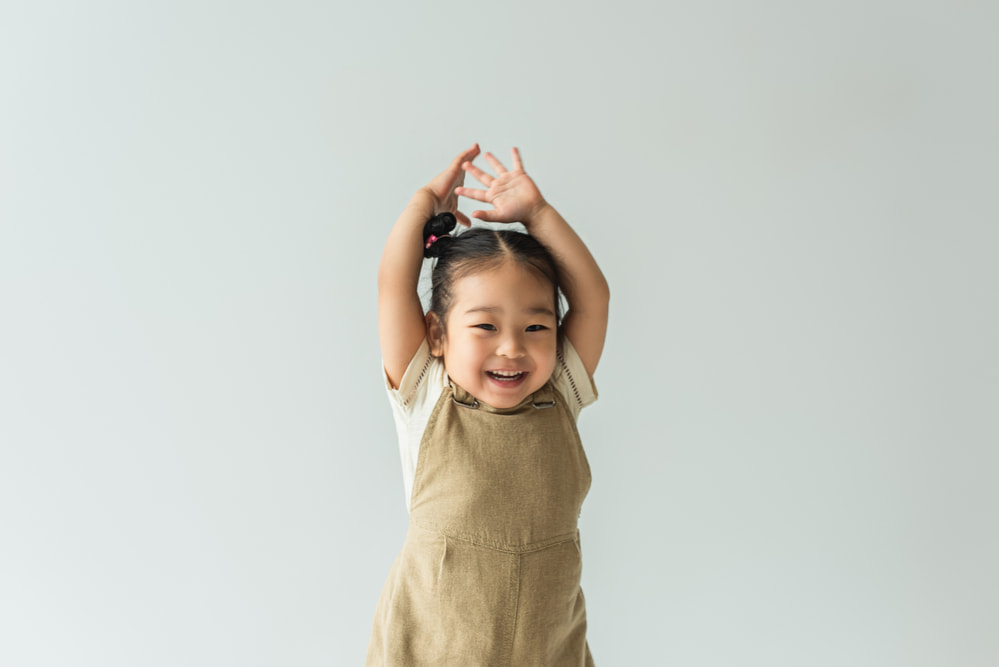 picture of toddler girl in overall dress smiling