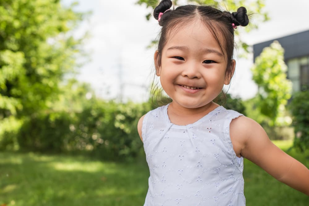 picture of toddler girl smiling with bun pigtails