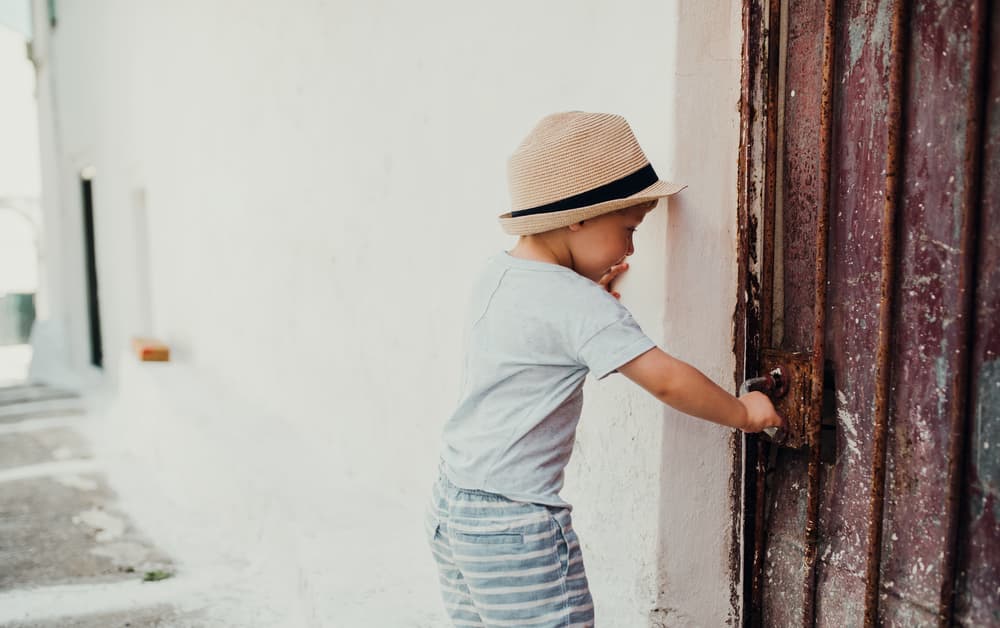 picture of toddler boy trying to open up a door