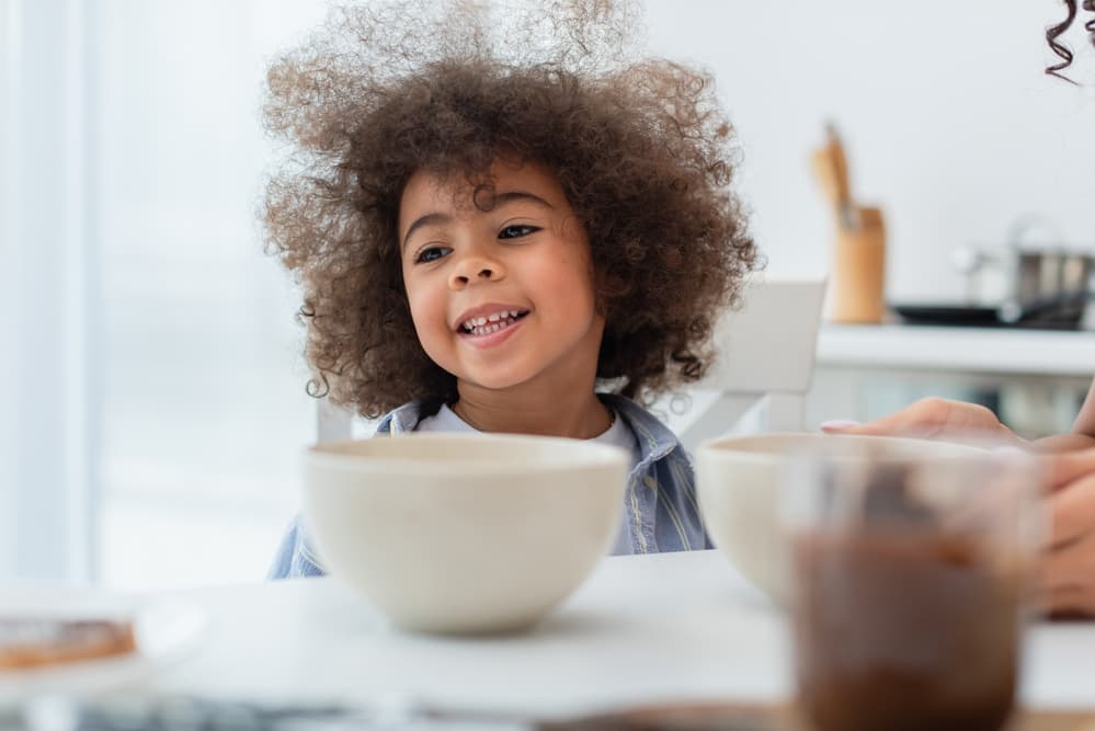 picture of little boy at table eating out of a bowl