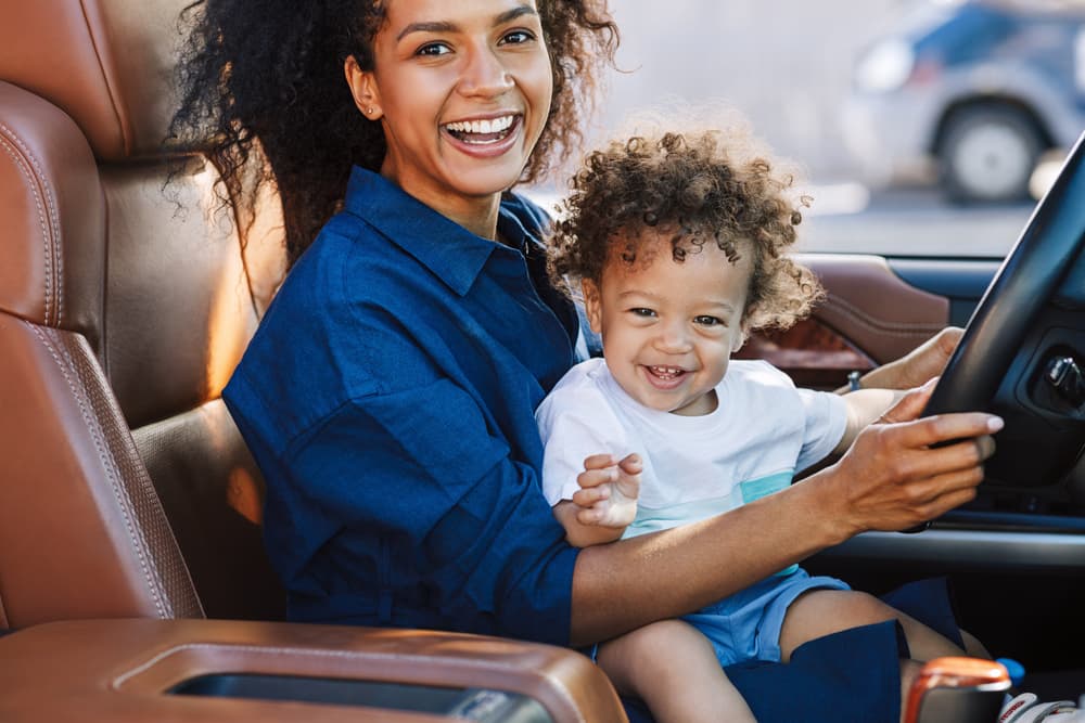 picture of mother and toddler son sitting in the front seat of a car