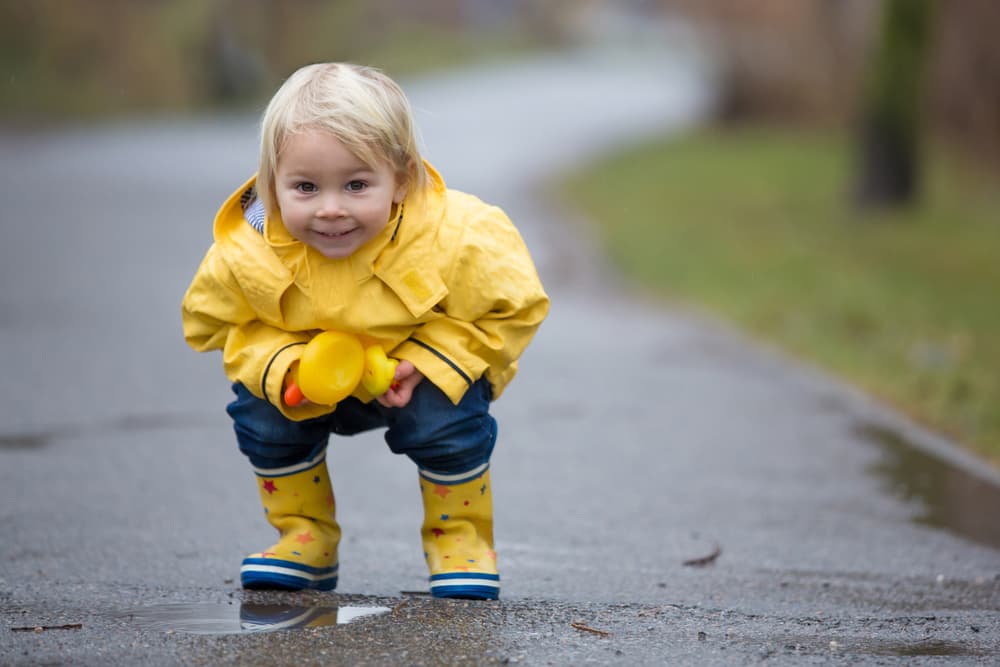toddler boy in rain jacket and rain boots