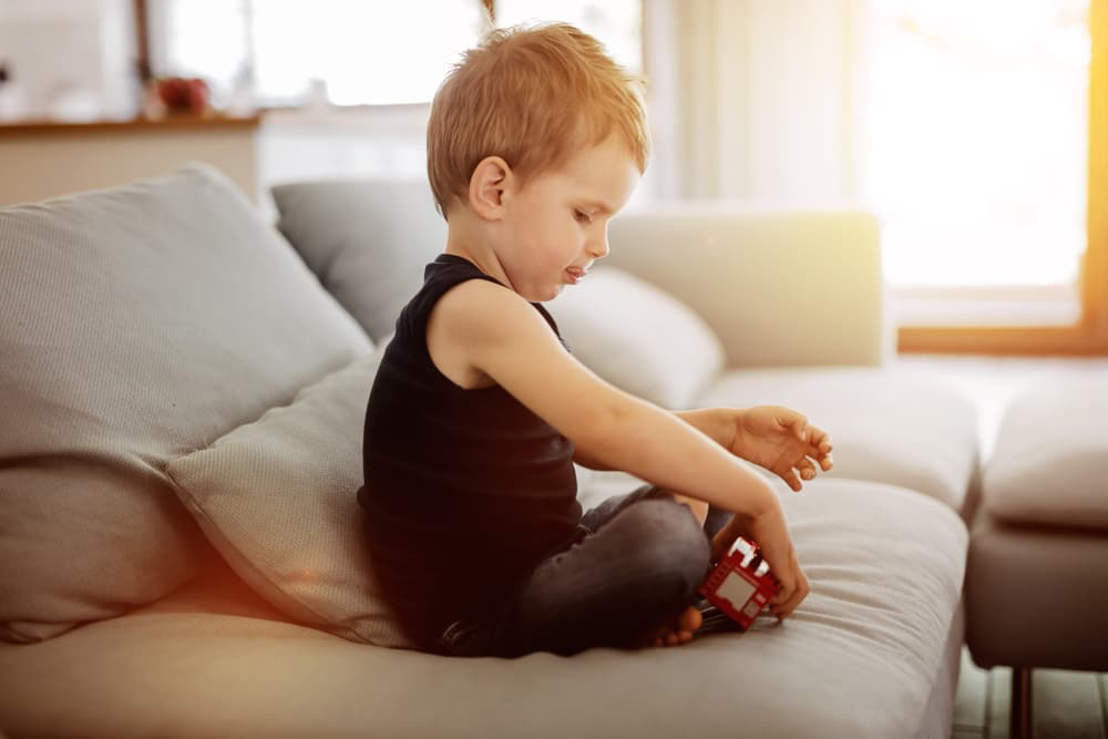 picture of little boy sitting cross legged on couch