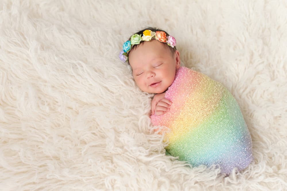 photo of newborn in a rainbow swaddle