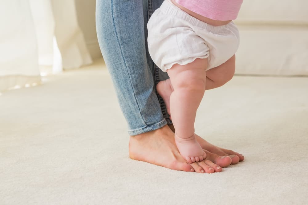 image of baby feet standing on top of mother's feet