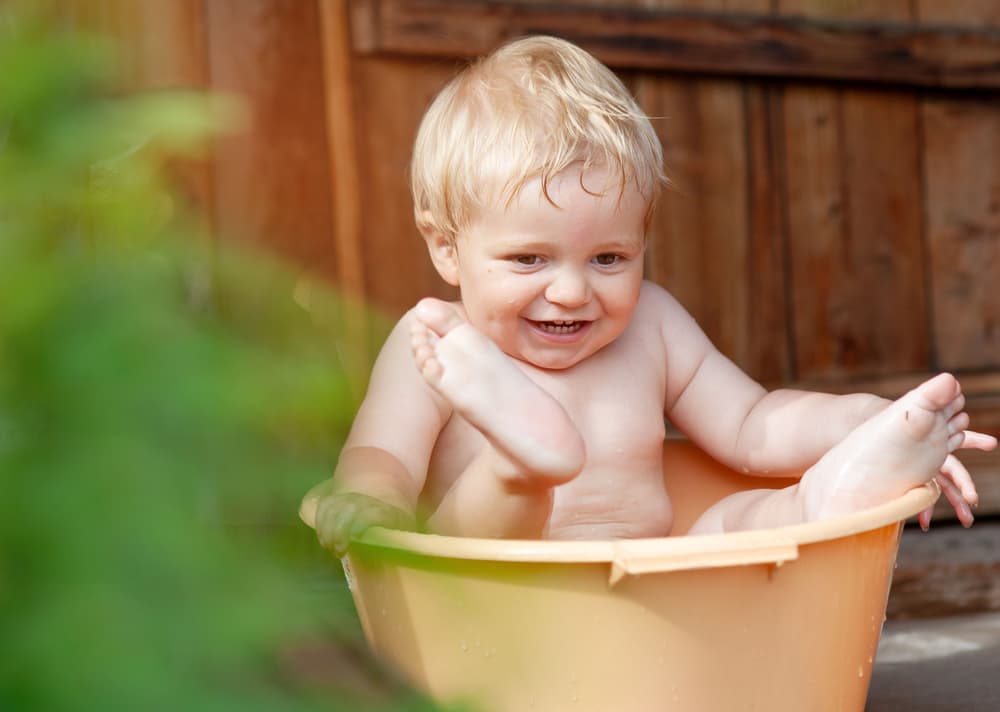 toddler boy playing in tub of water