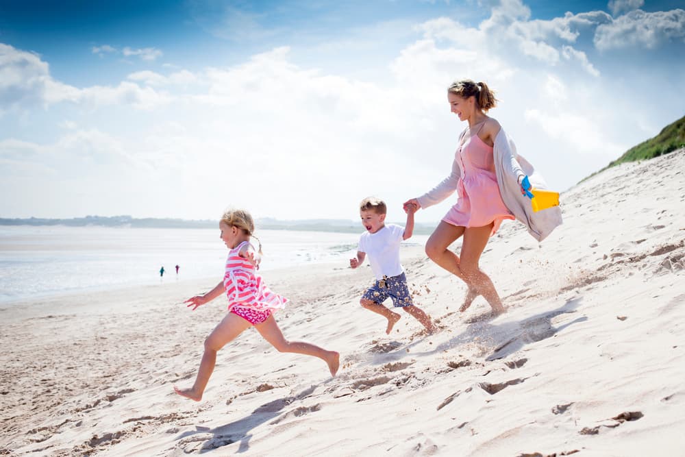 picture of mother with son and daughter running on the beach
