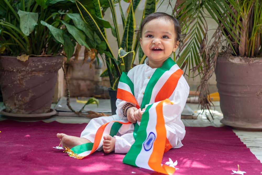 picture of girl in traditional Indian wear with Indian flag draped around her